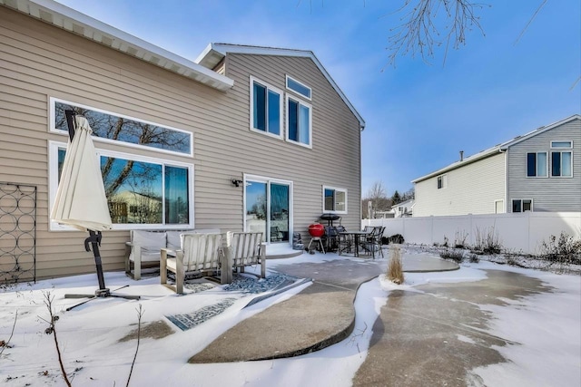 snow covered rear of property featuring outdoor lounge area and a patio