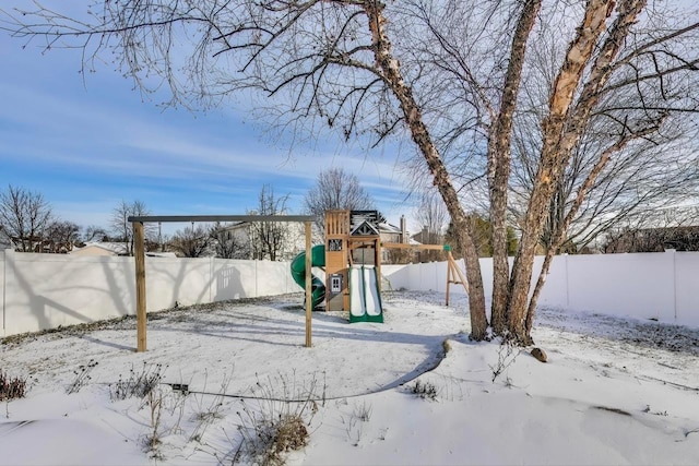 yard covered in snow with a playground