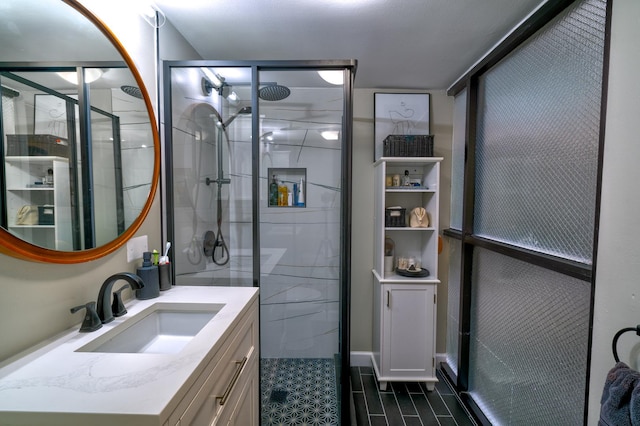 bathroom featuring a shower with door and vanity