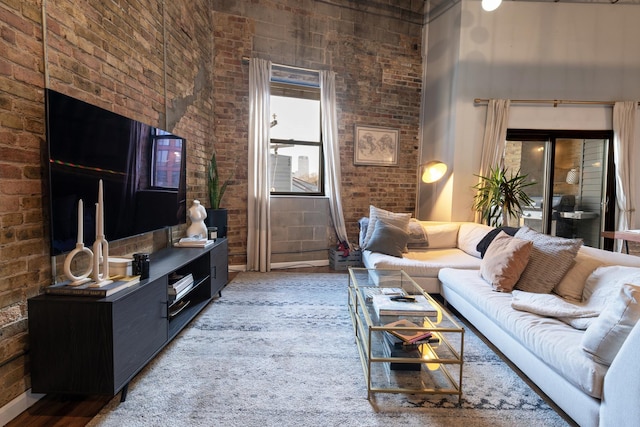 living room featuring brick wall and a high ceiling