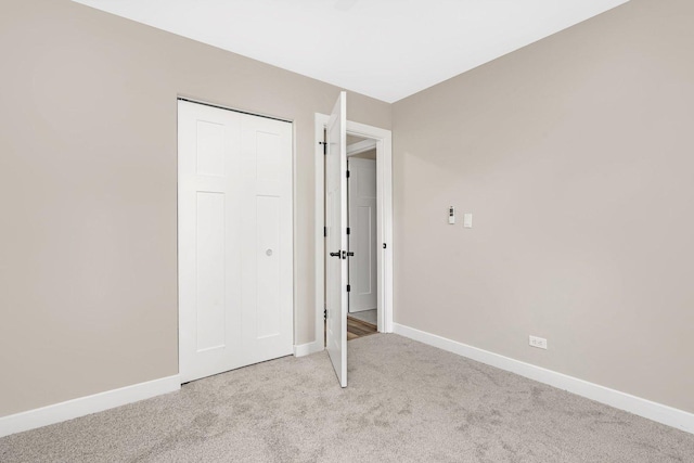 unfurnished bedroom with light carpet and a closet