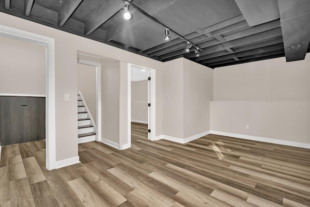 basement with light wood-type flooring and rail lighting