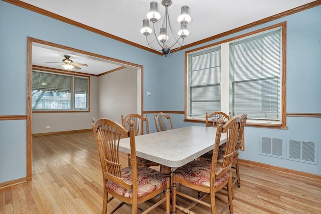 dining room featuring crown molding, light hardwood / wood-style flooring, and ceiling fan with notable chandelier