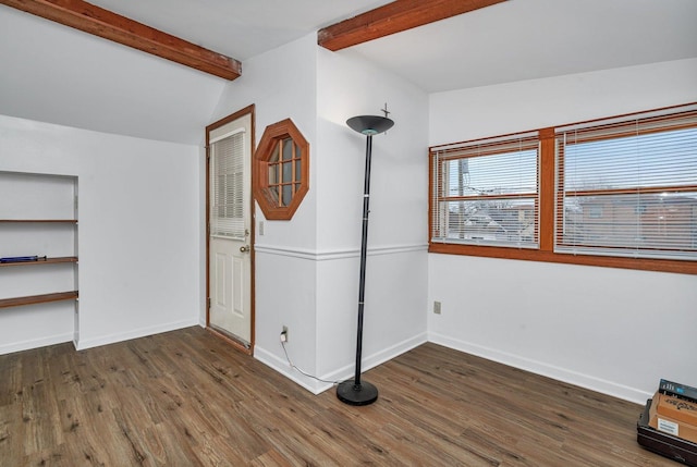 unfurnished bedroom featuring lofted ceiling with beams and dark wood-type flooring