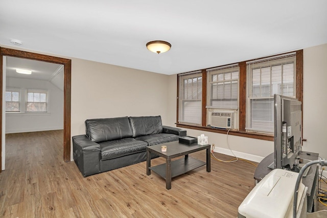 living room with cooling unit, light hardwood / wood-style floors, and vaulted ceiling