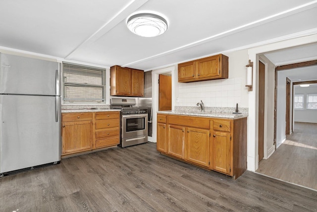 kitchen with sink, dark hardwood / wood-style flooring, stainless steel appliances, and tasteful backsplash