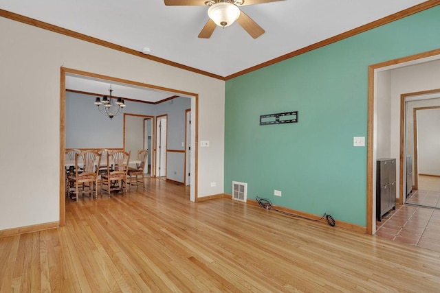 unfurnished room featuring light wood-type flooring, ceiling fan with notable chandelier, and crown molding