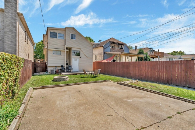 back of house with central AC, a yard, a patio, and a fire pit