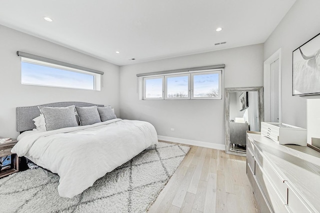 bedroom featuring multiple windows and light hardwood / wood-style floors