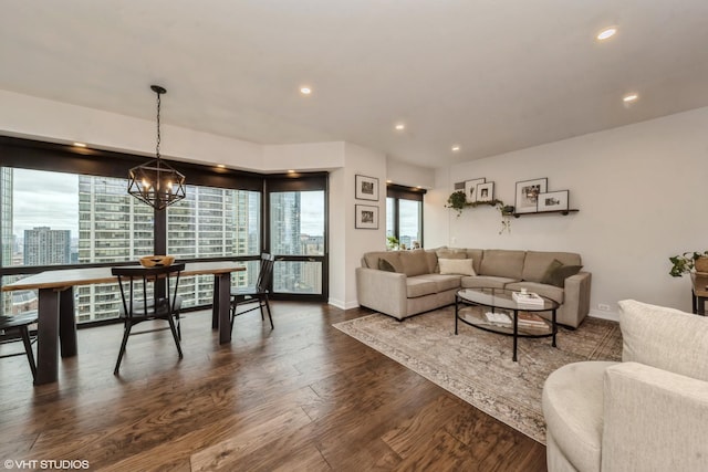 living room with a notable chandelier and dark wood-type flooring