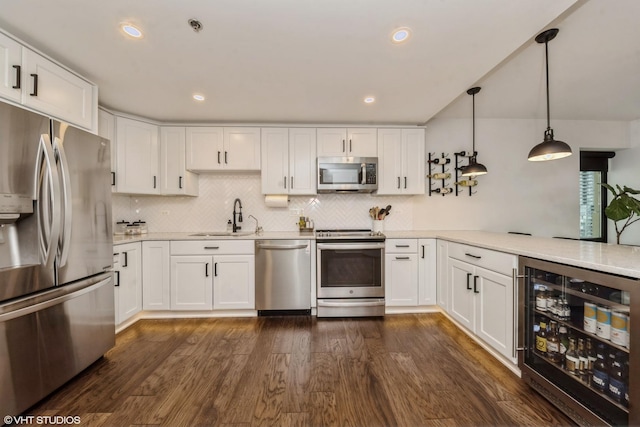 kitchen featuring white cabinets, hanging light fixtures, beverage cooler, and stainless steel appliances