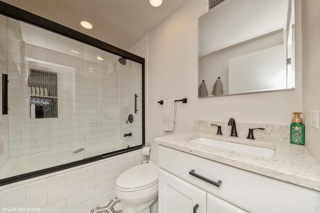 full bathroom featuring vanity, enclosed tub / shower combo, and toilet