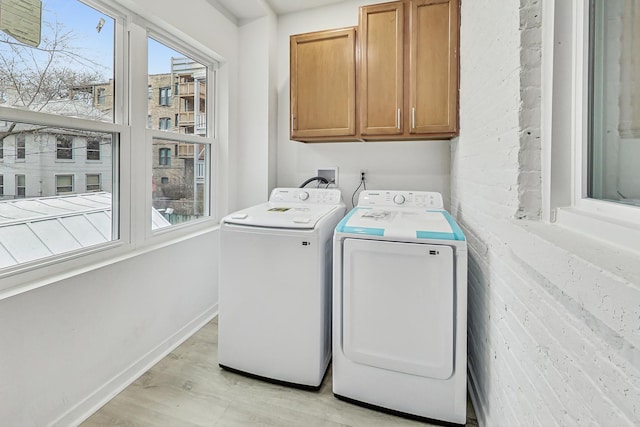 washroom with cabinets, light wood-type flooring, and independent washer and dryer