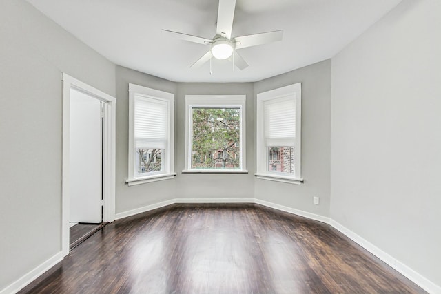 empty room featuring ceiling fan and dark hardwood / wood-style flooring