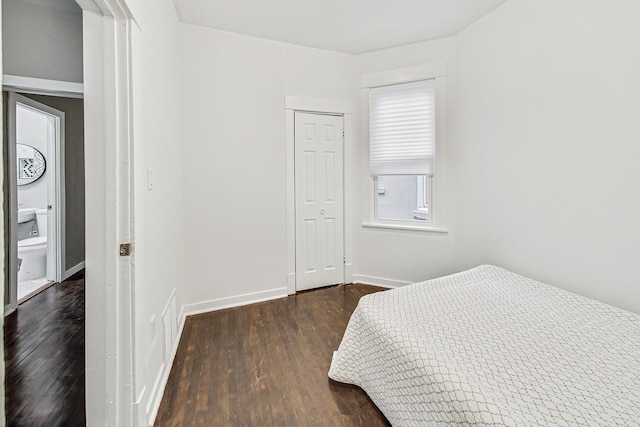 bedroom with dark hardwood / wood-style floors and a closet