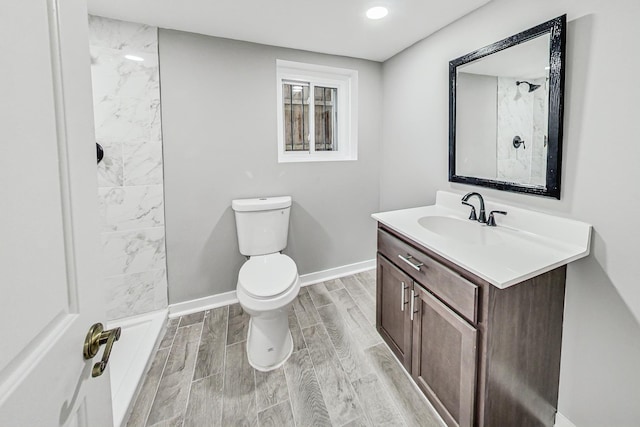 bathroom featuring vanity, toilet, and tiled shower