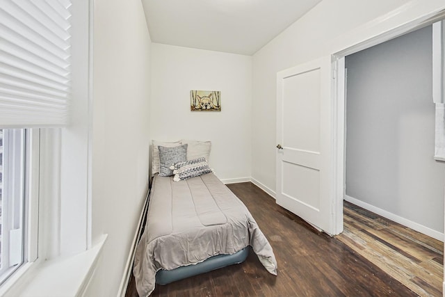 bedroom with dark hardwood / wood-style flooring