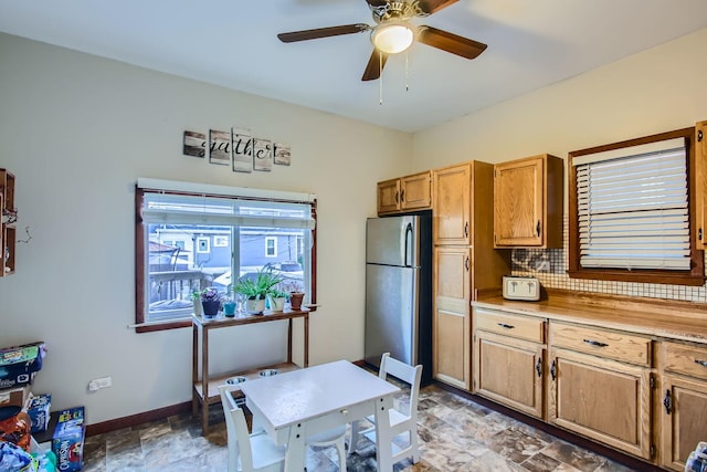 kitchen featuring decorative backsplash, stainless steel fridge, and ceiling fan