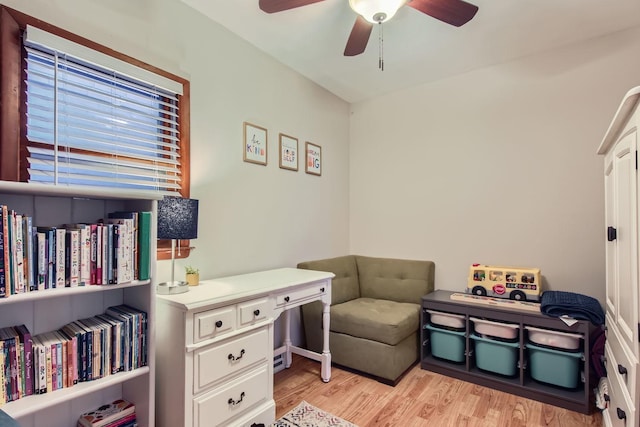 living area with light hardwood / wood-style floors and ceiling fan