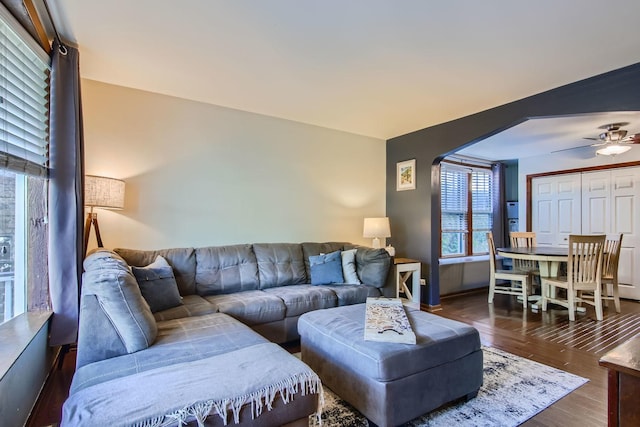 living room featuring ceiling fan and dark wood-type flooring