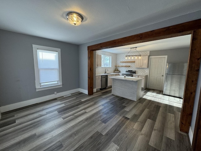 kitchen featuring pendant lighting, a center island, sink, decorative backsplash, and stainless steel appliances