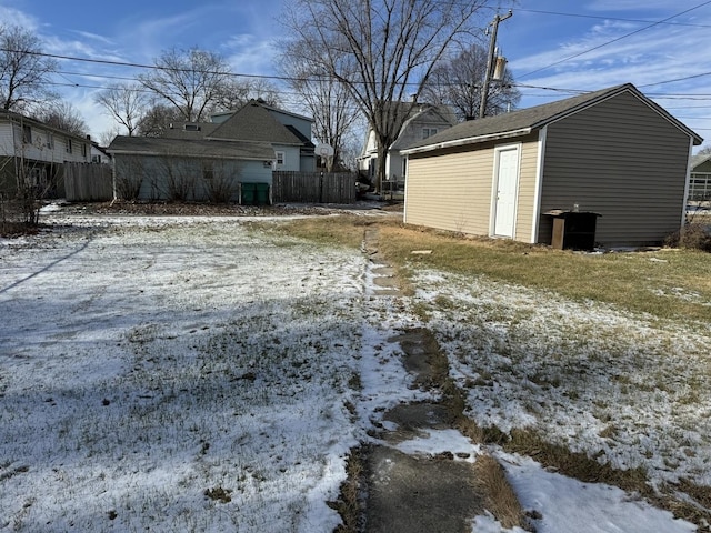 snowy yard featuring an outdoor structure