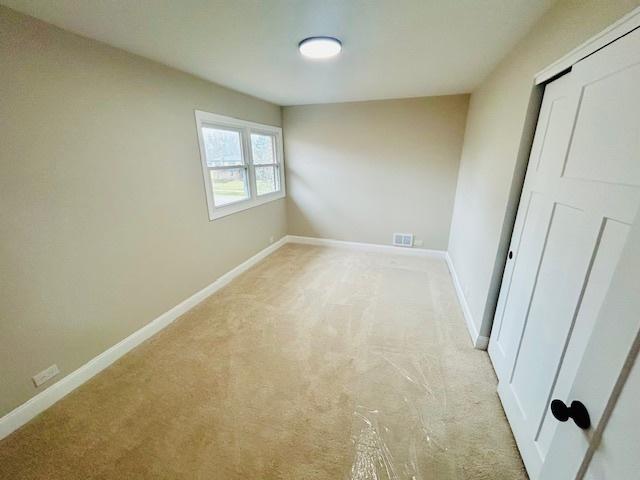 unfurnished bedroom with light colored carpet