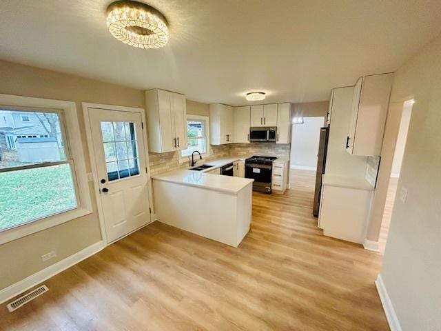 kitchen featuring sink, white cabinetry, stainless steel appliances, and light wood-type flooring