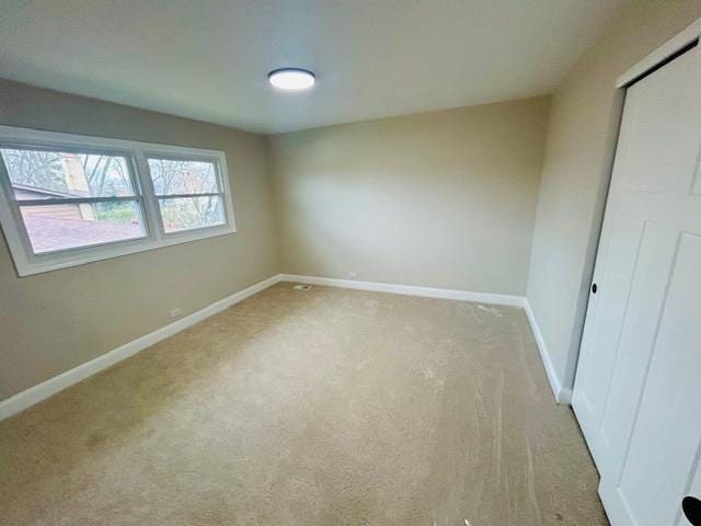 unfurnished bedroom with light carpet and a closet