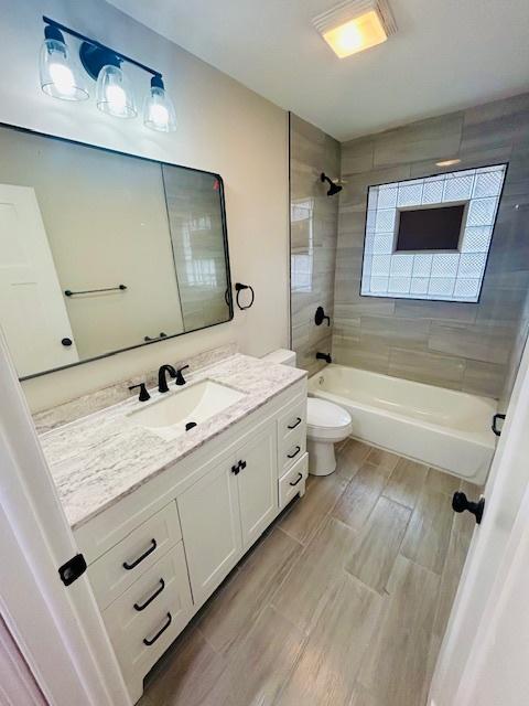 full bathroom with vanity, toilet, and tiled shower / bath combo