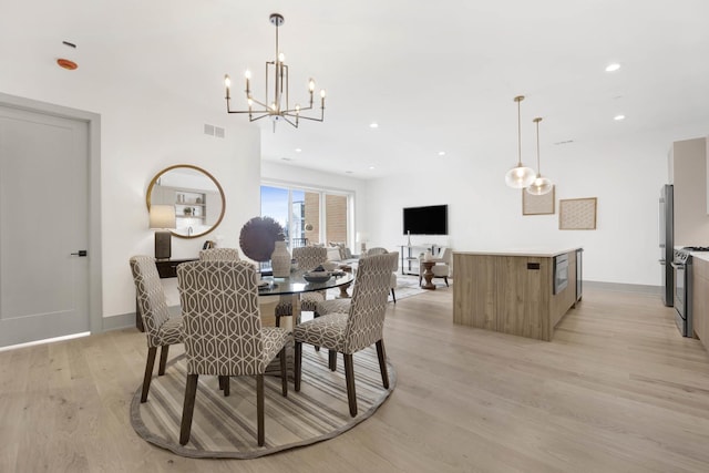 dining area featuring light hardwood / wood-style floors and a chandelier