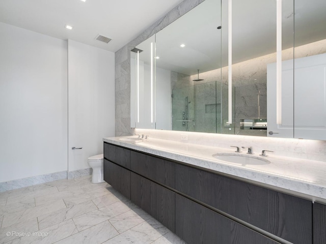 bathroom with a shower with door, vanity, and toilet