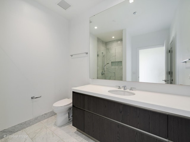 bathroom featuring a shower with door, vanity, and toilet