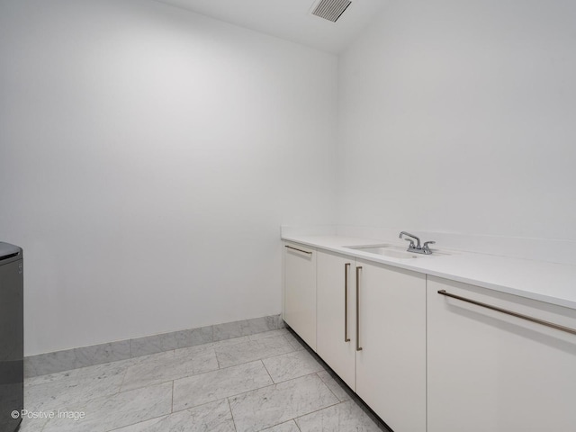 laundry area featuring sink and light tile patterned floors