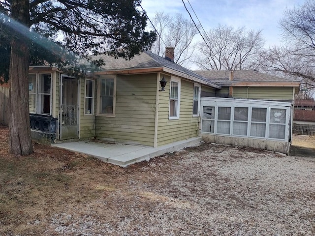 view of property exterior with a patio area and a sunroom