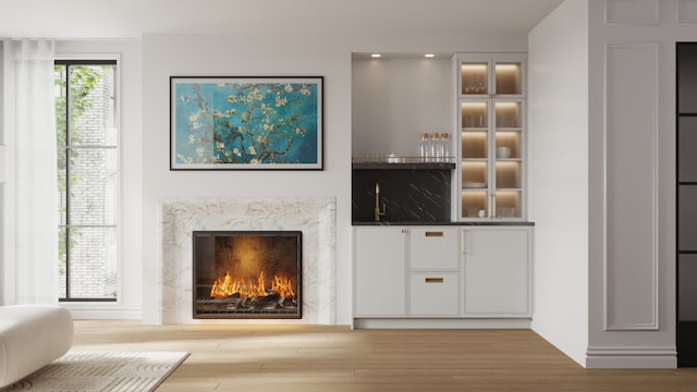 interior space with white cabinetry, a premium fireplace, and light hardwood / wood-style flooring