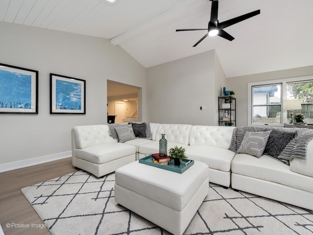 living room featuring ceiling fan, light hardwood / wood-style flooring, and lofted ceiling with beams