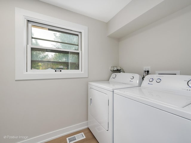 laundry area featuring hardwood / wood-style flooring and washing machine and clothes dryer