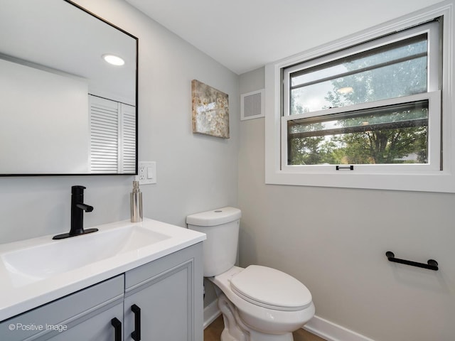 bathroom with vanity, toilet, and a wealth of natural light