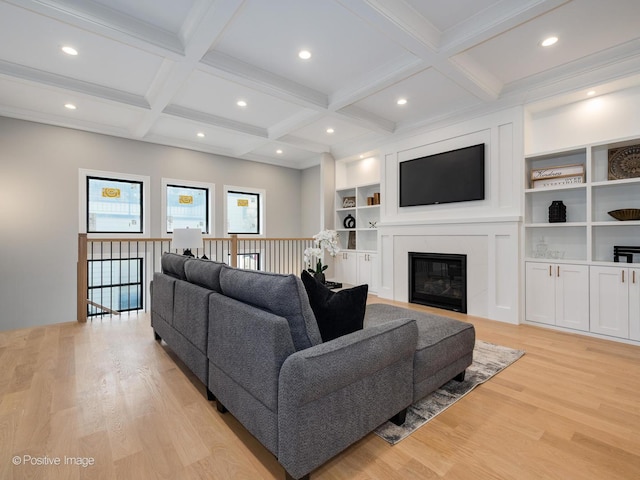 living room featuring a fireplace, beamed ceiling, light hardwood / wood-style floors, and coffered ceiling