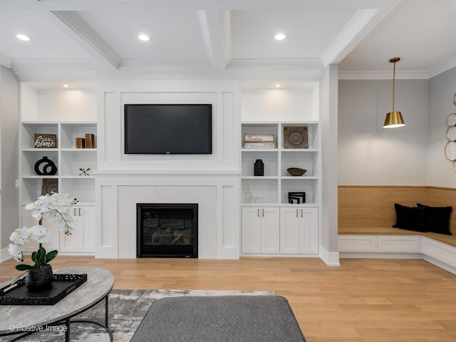 living room featuring beamed ceiling, light hardwood / wood-style floors, a premium fireplace, and crown molding