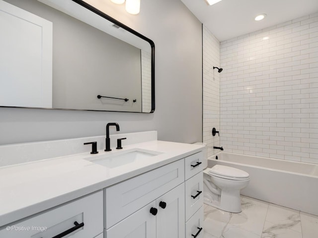 full bathroom with vanity, tiled shower / bath combo, and toilet