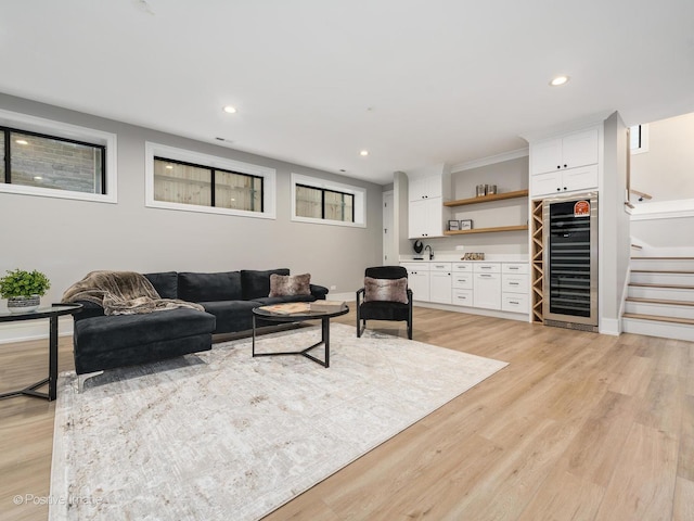 living room featuring sink, beverage cooler, and light hardwood / wood-style flooring