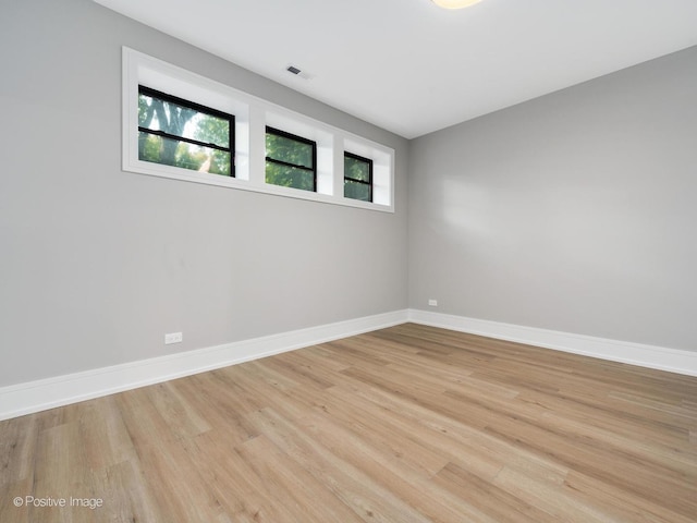 empty room with light hardwood / wood-style flooring and a wealth of natural light