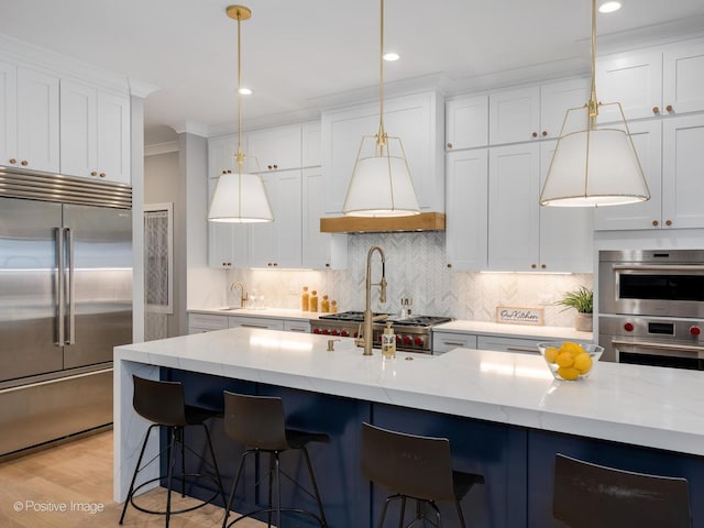 kitchen with white cabinets, backsplash, stainless steel appliances, and light stone countertops