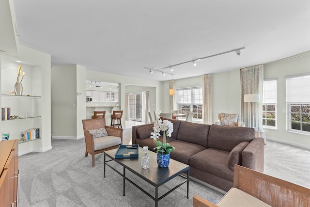 carpeted living room with track lighting