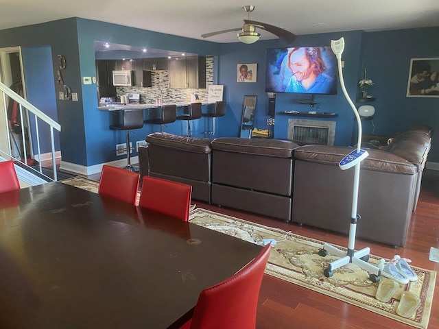 living room with ceiling fan and dark wood-type flooring