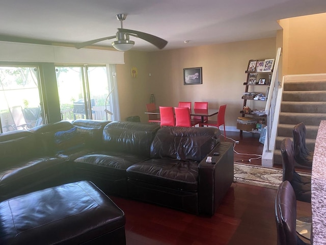 living room featuring ceiling fan and dark wood-type flooring