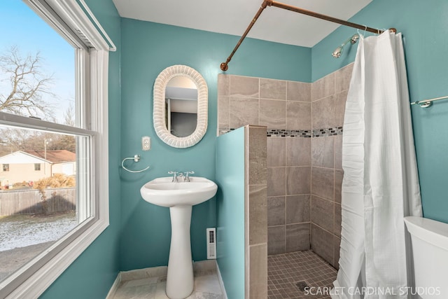 bathroom featuring a shower with shower curtain and toilet