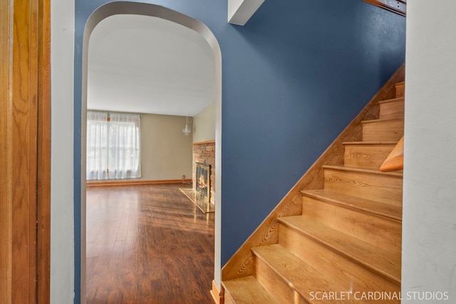 staircase featuring a fireplace and hardwood / wood-style floors